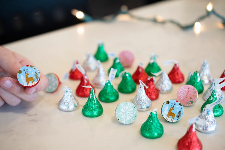 Hershey's kisses lined up on a counter with several turned over showing matching stickers on the bottom