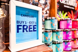 a sign at Bath & Body Works that says "buy one get one free" for candles