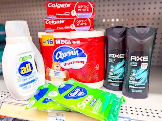 all detergent, charmin toilet paper, oral b floss picks, colgate toothpaste, and axe body wash on a shelf