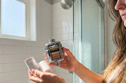 a woman holding a shower filter