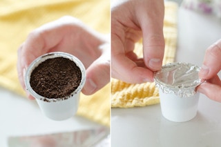An old K-cup filled with coffee grounds. A person putting aluminum foil over the k-cup.