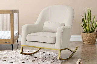 Lifestyle image of a velvet rocking chair in nursery setting