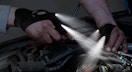 a person using flashlight gloves while working on a car
