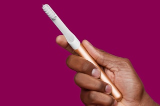 Lifestyle/stock image of hand holding Quip Electric Toothbrush 
