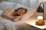 a candle warmer on a desk next to a person sleeping