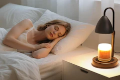 a candle warmer on a desk next to a person sleeping