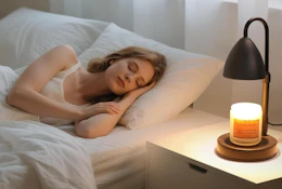 a candle warmer on a desk next to a person sleeping