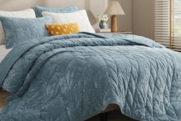 ash blue velvet quilt on bed