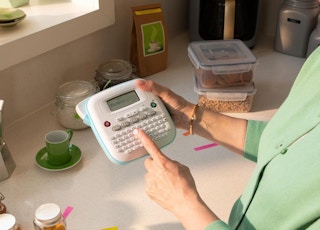 a person holding a label make in a kitchen