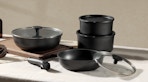 black pots and pans with lids on a table 