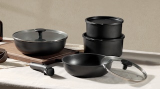 black pots and pans with lids on a table 