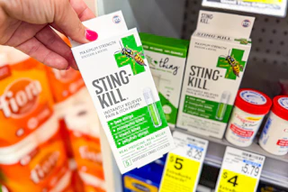 person grabbing sting-kill pain reliever off the shelf