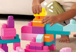 child playing with pink multi-colored mega bloks