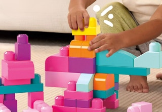 child playing with pink multi-colored mega bloks