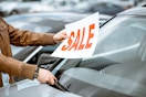 Person putting a sale sign on their car