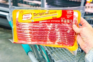 hand holding a pack of oscar mayer bacon