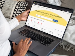 A person using a laptop looking at the GoodRx.com homepage