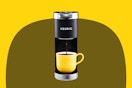 Stock image of the Keurig Mini Coffee maker in back with a yellow coffee mug