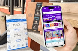 someone looking at amazon haul on their phone next to amazon boxes