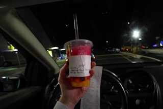 Someone holding a cup of the CosMc's Medium Sour Cherry Energy Burst drink. (Courtesy of Nick DiGiovanni https://www.youtube.com/watch?v=pp4CDtrhmCQ)