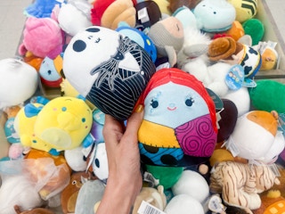 A variety of squishmallows sitting in a display at a store.