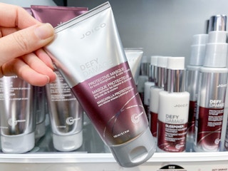 Woman holding bottle of Joico protective hair mask.