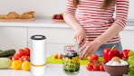 a person chopping vegetables next to a mason jar vacuum sealer and jar