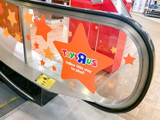 toys r us signage on macys store escalator