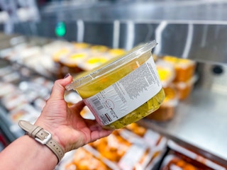 hand holding a tub of kirkland chicken soup