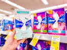 hand holding always pads next to sale tags on a shelf