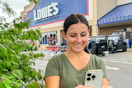 a woman looking at her phone outside of lowes