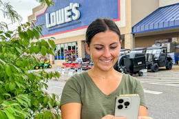 a woman looking at her phone outside of lowes