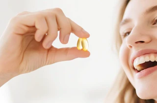 a person holding two softgels 