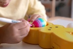 a boy decorating an egg on a peeps eggmazing egg decorator toy