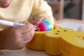 a boy decorating an egg on a peeps eggmazing egg decorator toy