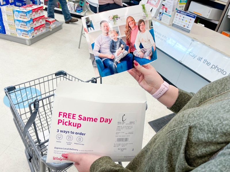 woman holding walgreens photo packet and holding a 8x10 print