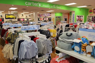 A Carter's oulet store with children's clothing on racks and shelves.