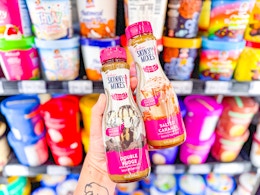 hand holding two bottles of skinny mixes in walmart aisle
