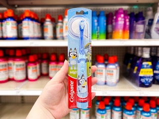 hand holding a Colgate Bluey battery-powered toothbrush