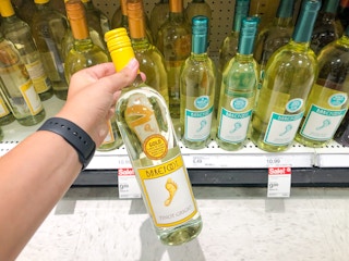 hand holding bottle of Barefoot wine in store aisle