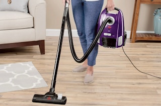 a woman using a bissell vacuum