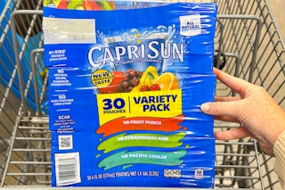 hand holding a box of capri sun in shopping cart