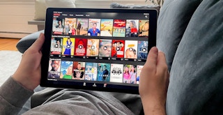A person looking at the movie and TV show selection on Netflix using an ipad