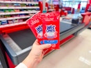 hand holding wet ones wipes in front of a checkout lane