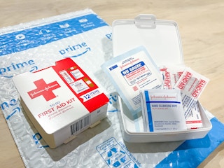 first aid kit opened with band-aids on an amazon package
