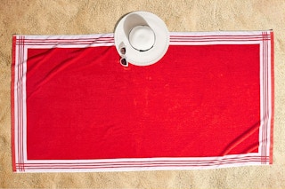 Lifestyle image of the Better Homes & Gardens Resort Style Beach Towel in red