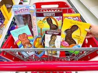 a target cart with the top basket filled with different types of chocolate easter bunnies