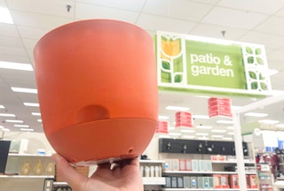 hand holding plastic planter inside store