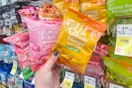 person holding bags of peelable gummy candy