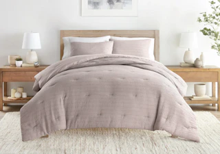 a comforter set on a bed in a room